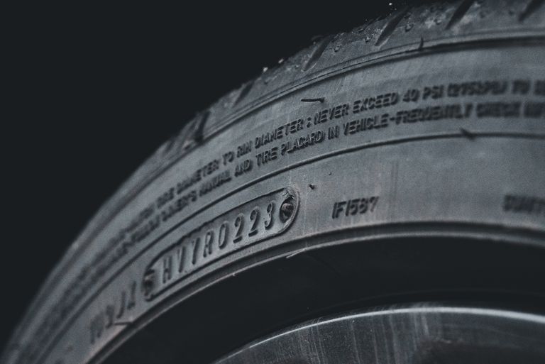 Detailed close-up image of a black car tire showcasing sidewall text and treads.